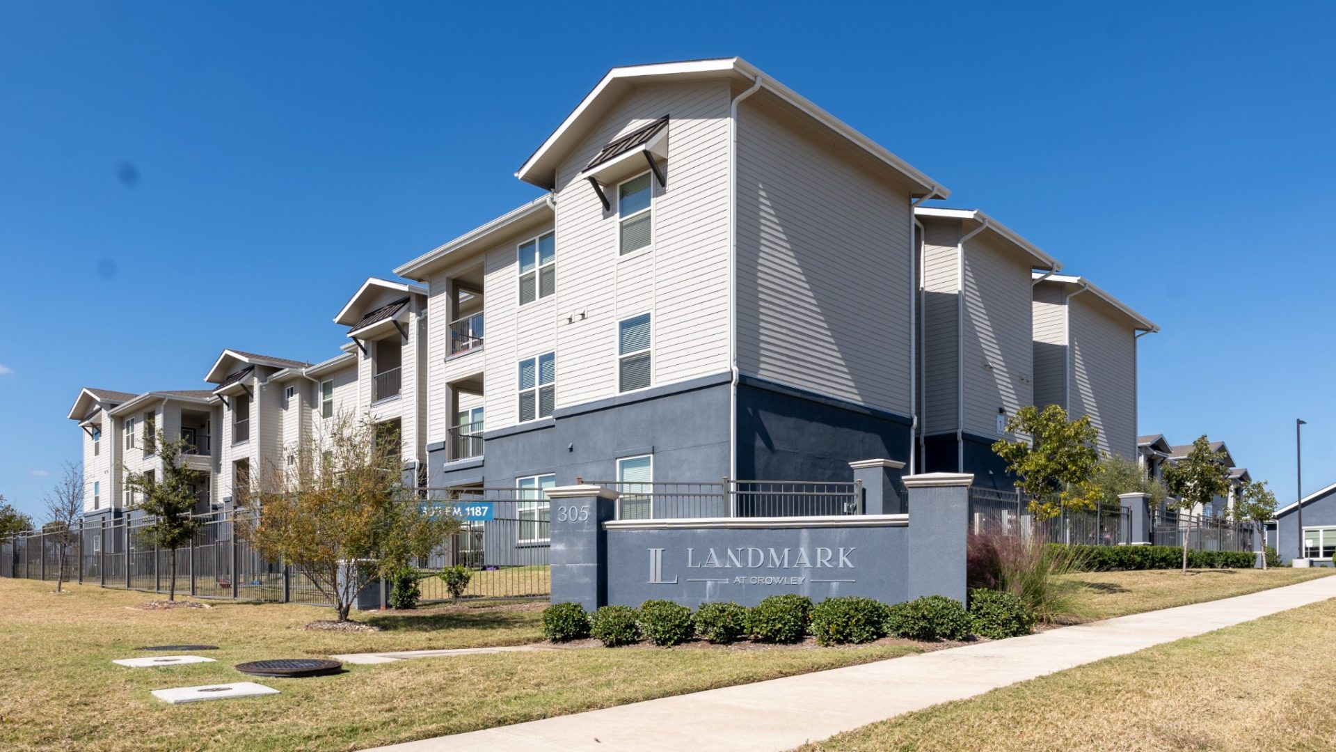 the exterior of an apartment complex with a sign that says, apartment at The Landmark at Crowley